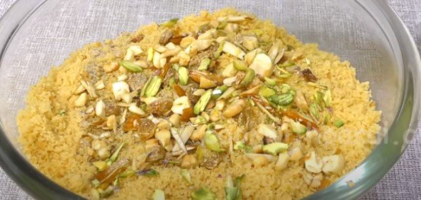 mixing fried dry fruits in rava besan ladoo mix