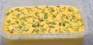 garnishing mango ice cream with chopped pistachio